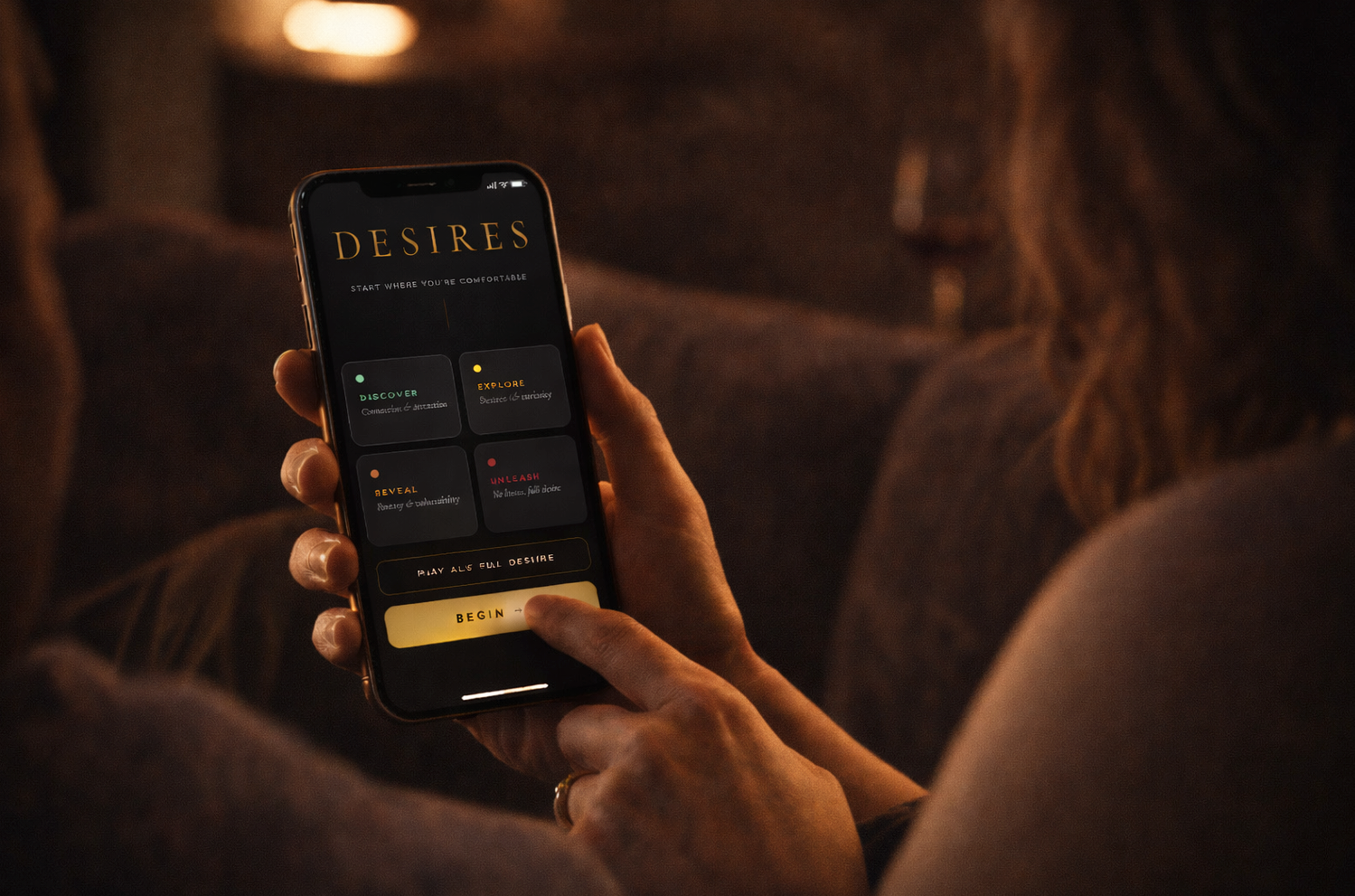 woman on couch holding phone playing DESIRES